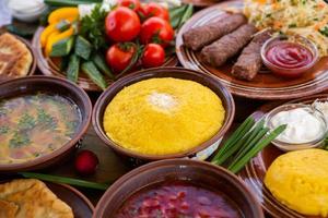 Homemade Romanian Food with  pies, polenta, borscht, vegetables, fish, meat, stew, cheese and wine. Traditional dishes from Romania and the Republic of Moldova. photo