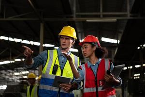 The foreign chief engineer came to inspect the old mechanical factory. There is an African female mechanic explaining details and progress reports photo