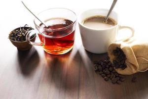 Coffee and tea with coffee bean and tea leaves on wooden floor. photo