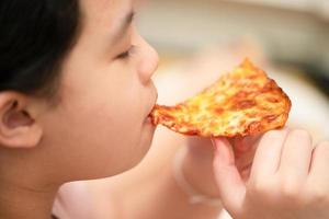 kid eats pizza photo