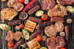 A large variety of grilled meat on the fire outside photo