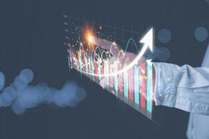 Hand of businessman touching pointing virtual screen on growth graph business with copy space. Investment stock market traded graph financial for-profit corporate in the future. Funds, digital assets. photo