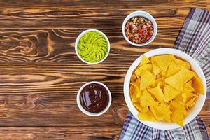 Mexican nachos with cheese. Corn chips with guacamole, salsa and tomato ketchup. photo