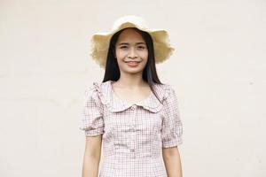 mujer asiática con un sombrero sonriendo alegremente foto