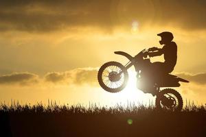 Silhouette of a motocross motorcycle lifting the front wheel. Adventure and Action Concepts photo