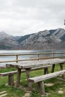 merendero con mesa y banco de madera. magnífica vista del embalse de agua en caldas de luna y las montañas alrededor. España foto