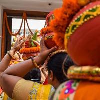 mujeres con kalash en la cabeza durante el templo jagannath mangal kalash yatra, devotos hindúes indios llevan ollas de barro que contienen agua sagrada con un coco encima foto