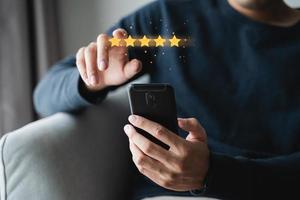 Close up of man customer giving a five star rating on smartphone. Review, Service rating, satisfaction, Customer service experience and satisfaction survey concept. photo