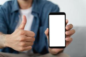 mano de hombre sosteniendo un teléfono inteligente de pantalla blanca vacía en blanco. foto