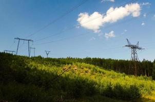 líneas eléctricas en las laderas de las montañas contra el fondo del bosque. foto