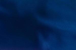 Luxury deep blue fabric background.Smooth wavy fold pattern.Elegant curve.Silk velvet material texture.Using for backdrop or wallpaper.Dark tone color. photo