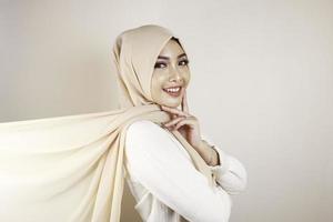 Muslim woman wearing traditional wear and hijab isolated on white background. Hijab is creatively made flying. Idul Fitri and hijab fashion concept. photo