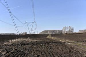 Ultra-high voltage power line in the field in spring in Russia photo