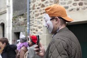 Douarnenez, France, 2-27-22-Man in Guy Fawkes mask filming with phone photo