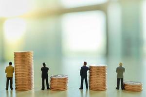 Business, Teamwork, Investment and Planning Concept.  Close up of group of businessman miniature people figure standing with stack of coins with copy space. photo