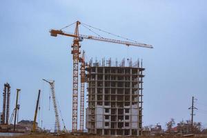 Concrete building in progress with cranes photo