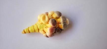 Stunted rainbow seed corn cob under a dim light and gray background. Zea mays plant. Crop failure season. photo