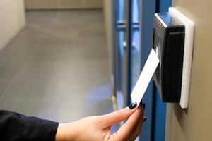 las mujeres alcanzan la mano para usar la tarjeta de acceso rfid para acceder al área del edificio de oficinas y al espacio de trabajo. en la seguridad del edificio solo para persona autorizada foto