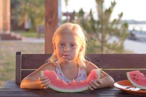 funny kid girl eat watermelon slices photo