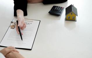 Real estate company to buy houses and land are delivering keys and houses to customers after agreeing to make a home purchase agreement and make a loan agreement. Discussion with a real estate agent photo