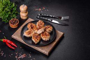 Delicious fresh fried minced meat patties on a dark concrete background photo