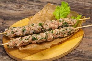 Raw minced pork skewer kebab for grill photo