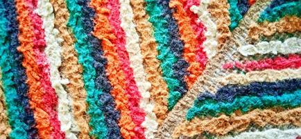 Variegated multicolor straight woven carpet texture. Fuzzy thin grunge vertical line textile material. Curly carpet rug fabric effect. photo