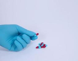 tomando o sosteniendo pastillas de medicamentos en la mano. píldora cápsula sobre fondo blanco. foto