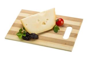 Maasdam cheese on wooden plate and white background photo