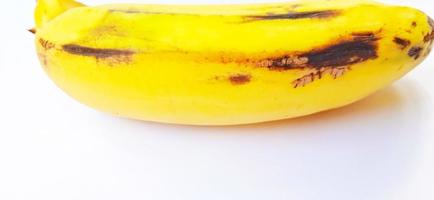 An isolated yellow ripe banana fruit on the gray background. Suitable for poster, backdrop, advertising, agriculture company and industry, etc. photo