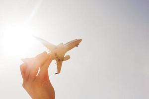 Airplane model in hand on sunny sky. Concepts of travel, transportation photo