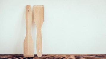 Wooden kitchen spatulas on brown table background photo