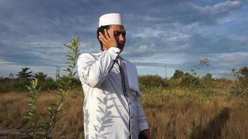 un hombre vestido de musulmán blanco está llamando a la oración video