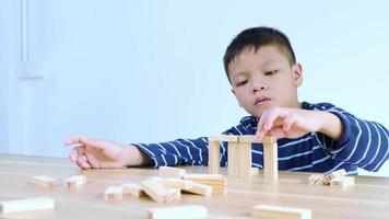 Asian boy playing with a wooden puzzle video