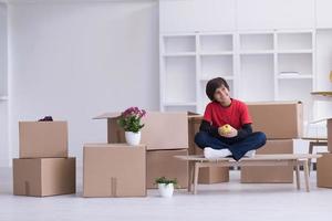 niño sentado en la mesa con cajas de cartón a su alrededor foto