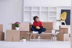 boy sitting on the table with cardboard boxes around him photo
