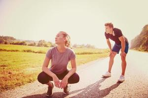 young couple warming up and stretching on a country road photo