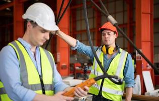 dos jóvenes ingenieros probando y comprobando el funcionamiento de la grúa semi pórtico foto