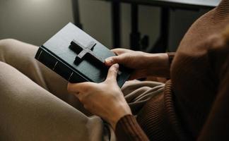 Woman sitting and studying the scriptures.The  wooden cross in the hands. Christian education concepts The Holy Scriptures open and pray to God. photo