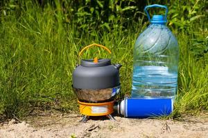 Picnic in nature. A gas burner and a mug of hot tea. photo