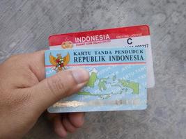 Sidoarjo, Jawa timur, Indonesia, 2022 -  a man holding two identity cards and a sim card photo