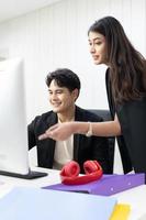 President and secretary using computer to working and  discuss together at office. businessman and businesswoman talking and looking computer in the office. photo