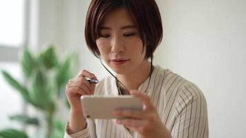 A woman studying on a smartphone video