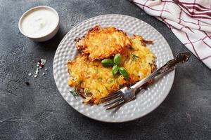 Fried cakes of grated potatoes on the plate with sauce. Traditional pancakes boxty raggmunk photo