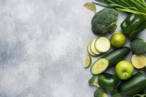 enmarque verduras y hierbas verdes frescas sobre un fondo de hormigón gris. copie el espacio foto