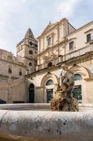 Noto,Italy-May 7, 2022 people stroll in Noto in front off the Church of San Francesco d'Assisi all'Immacolata during a sunny day photo