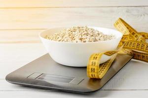 Oatmeal in a white plate on the kitchen scale photo