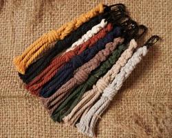 llavero de macrame, chupito de macrame, hecho a mano por mujeres en casa. excelentes imágenes de bricolaje para pancartas y anuncios de macramé y artesanías. diseño de pasatiempo creativo con accesorios, vista superior. macramé hecho a mano. foto