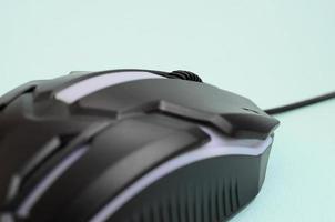 Closeup of a black gaming optical mouse on a blue background photo