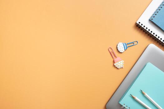 Stationary and laptop with paper clips on colored background. Copy space. Creative work space top view, flat lay. Online learning concept photo